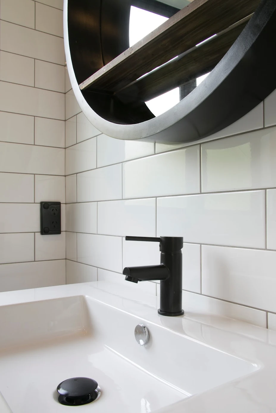 Matte black basin mixer against white subway tiles in an Epsom bathroom
