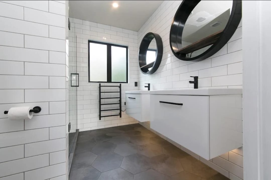 Twin wall-hung vanities and round mirrors in an Epsom bathroom renovation