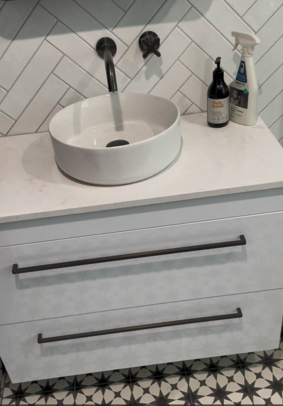 bathroom renovations st johns Drawer vanity with a round vessel basin and herringbone tiles in a St Johns bathroom