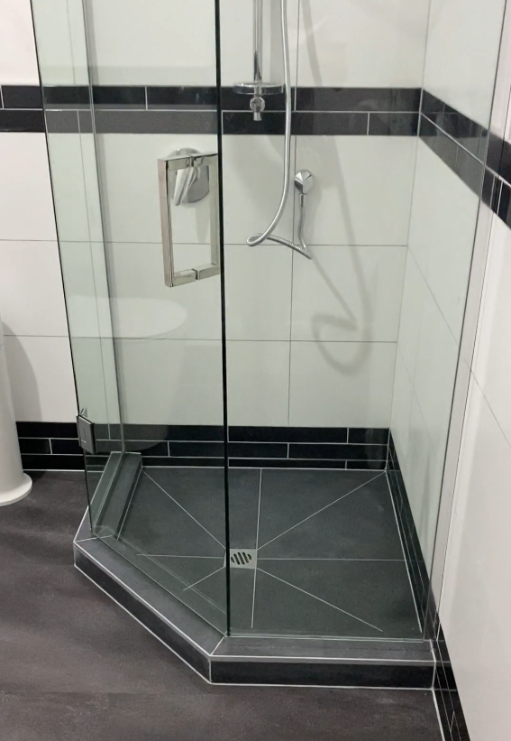 custom tiled shower in ponsonby Custom tiled shower with a black tiled base and frameless glass in a Ponsonby bathroom