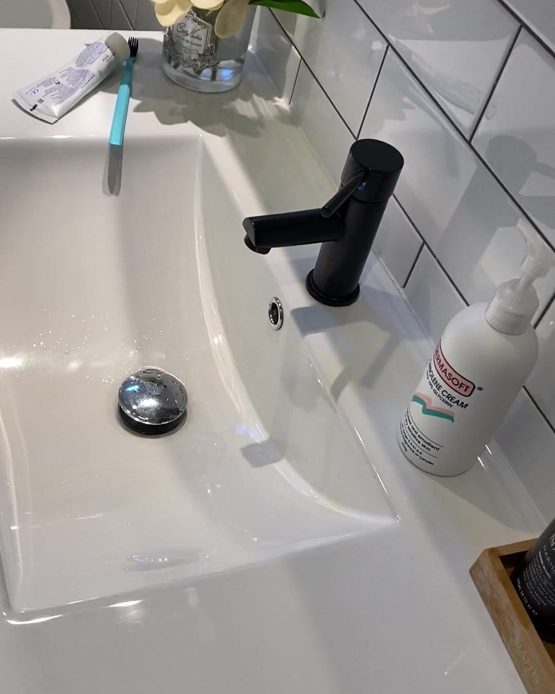 Matte black pin-lever mixer on a white ceramic basin top in a renovated Albany bathroom