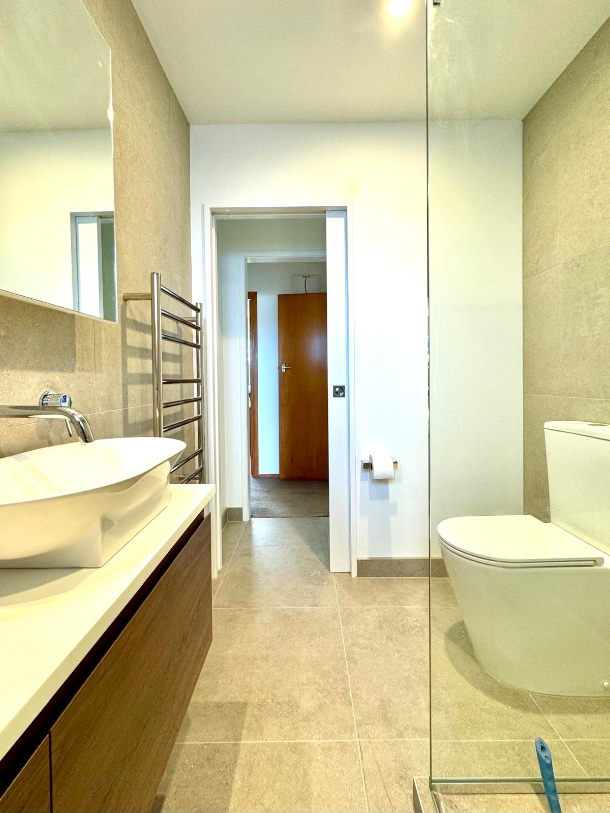 Finished bathroom with a vessel basin, timber vanity and glass shower