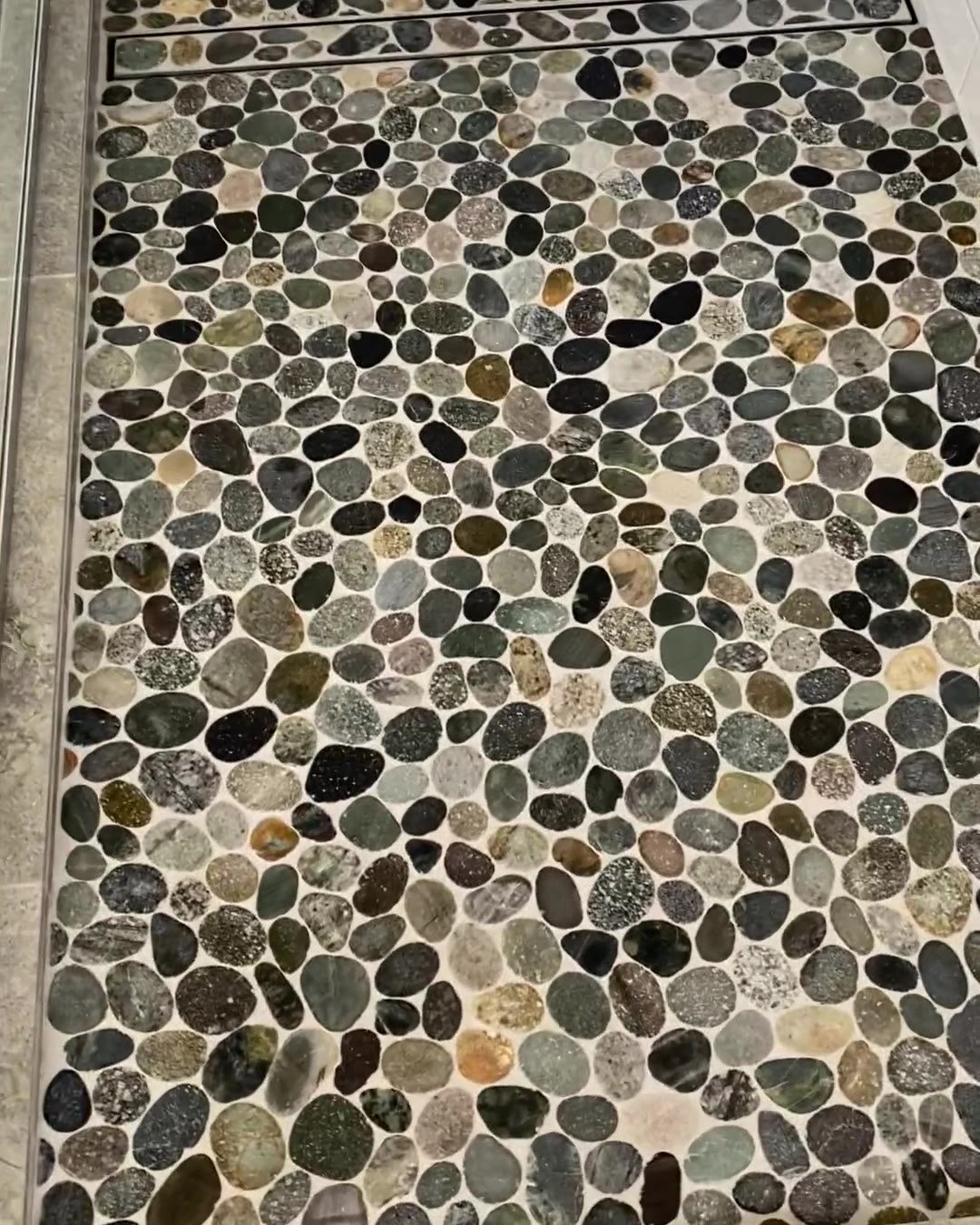 River-pebble shower floor with a linear strip drain in a Cockle Bay bathroom renovation
