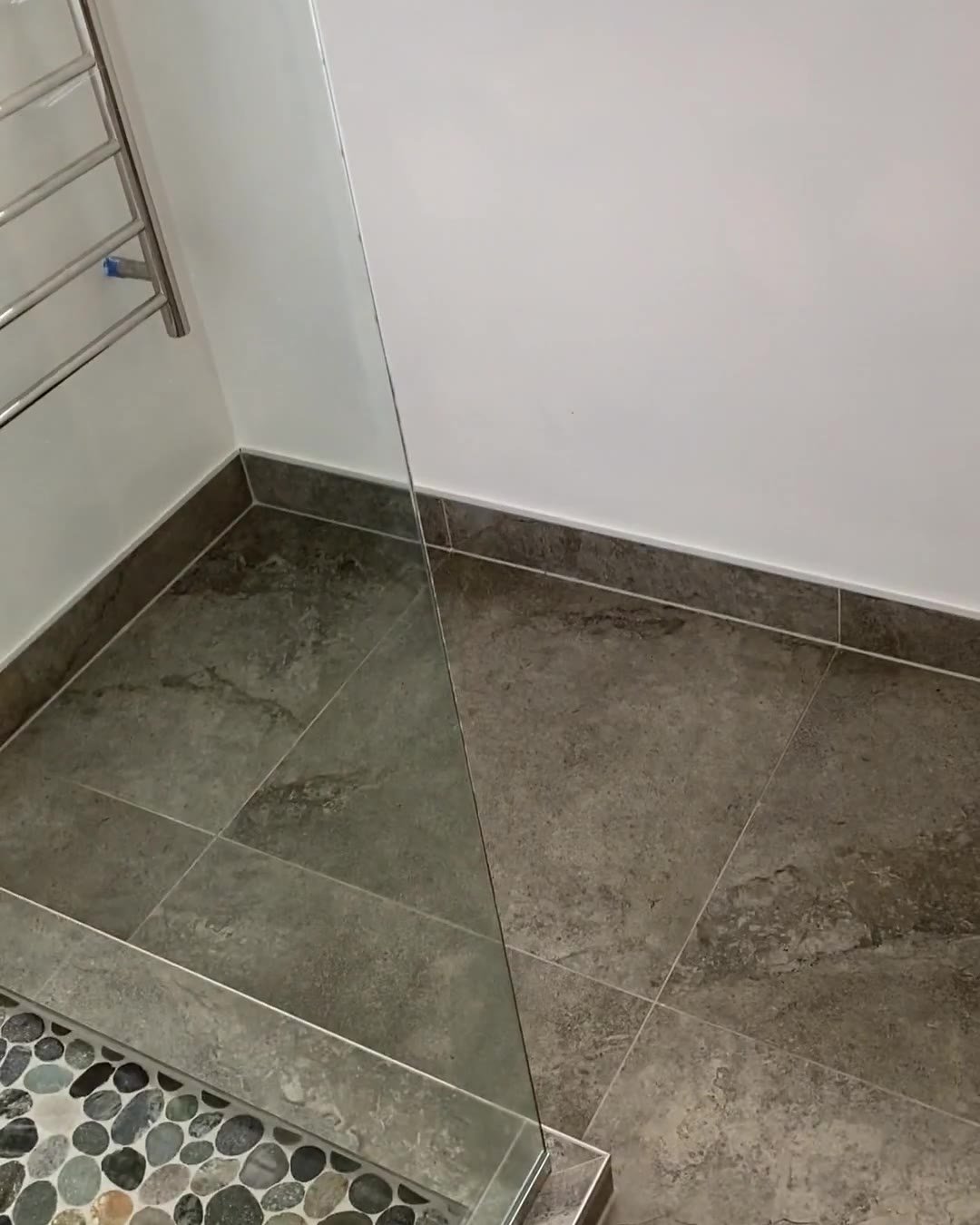 Heated towel rail and frameless glass panel beside the pebble shower, Cockle Bay