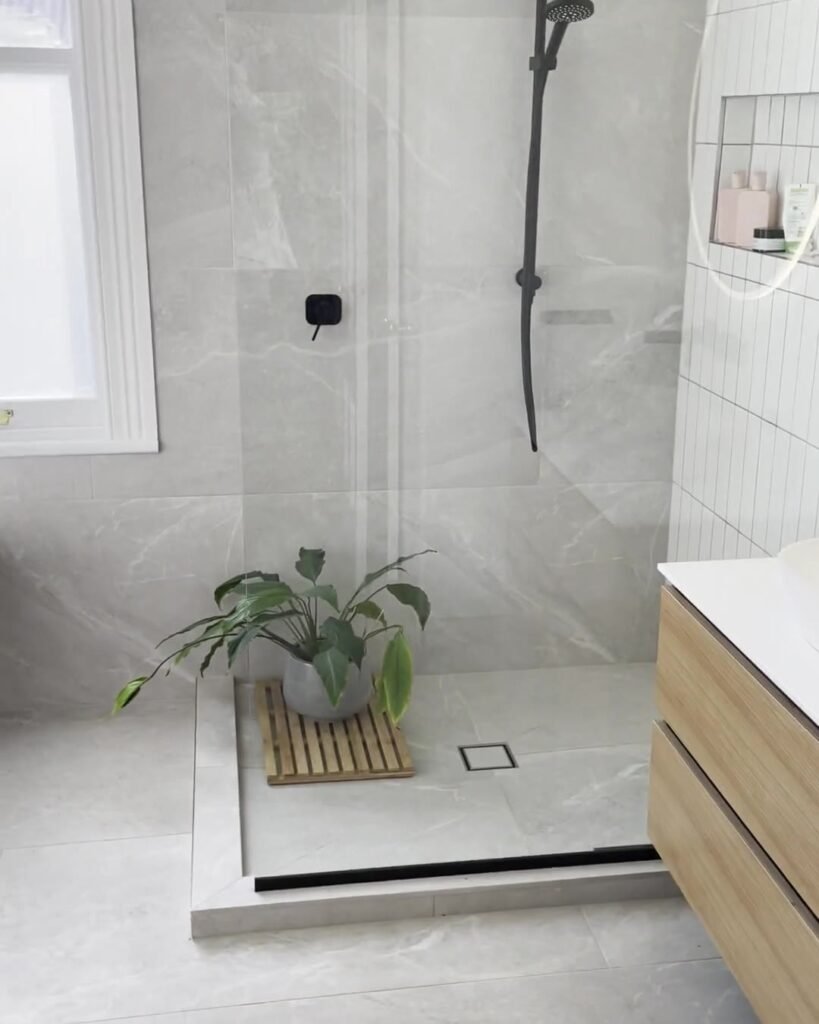 mount-eden-bathroom-shower Walk-in shower with a black rail shower and a fixed glass panel beside a sash window, Mount Eden