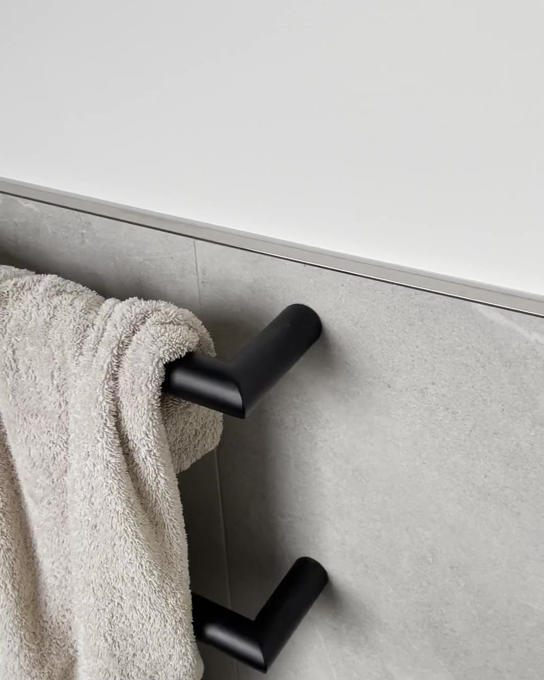 Matte black towel rail on waist-height grey tiles in a renovated Mount Eden bathroom