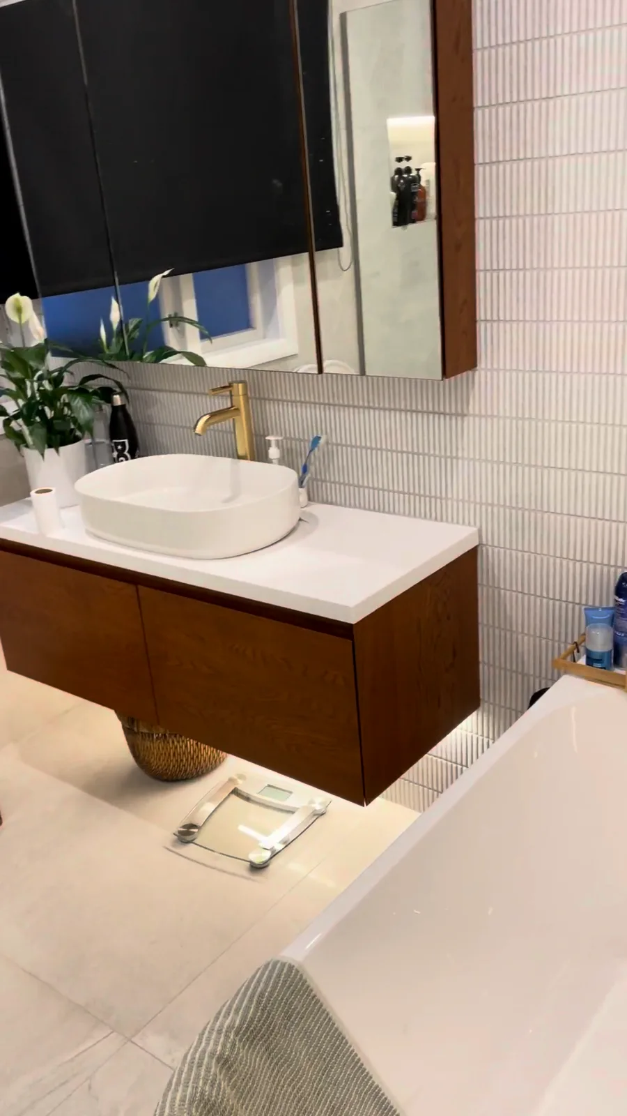Timber wall-hung vanity under a mirror cabinet with white finger mosaic tiles, Glendowie bathroom renovation