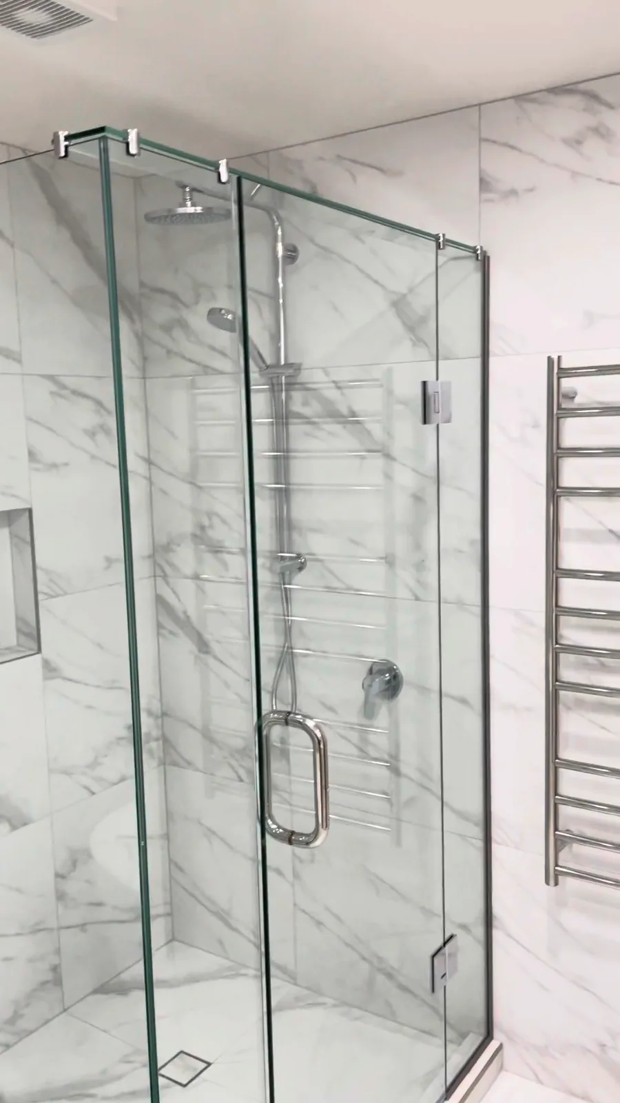 Glass corner shower with chrome rail shower and rain head in a renovated Kohimarama bathroom