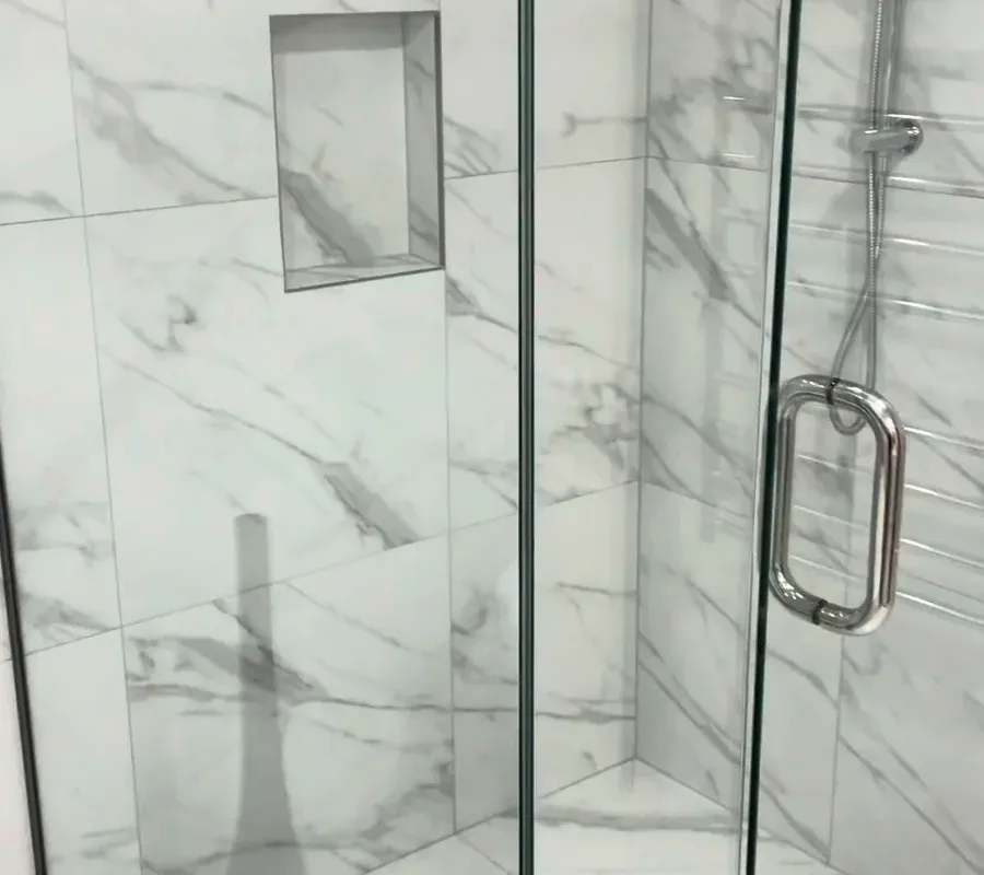 Tiled shower niche and square floor waste, Kohimarama (wide) Tiled shower niche with metal trim above a square floor waste in a Kohimarama shower