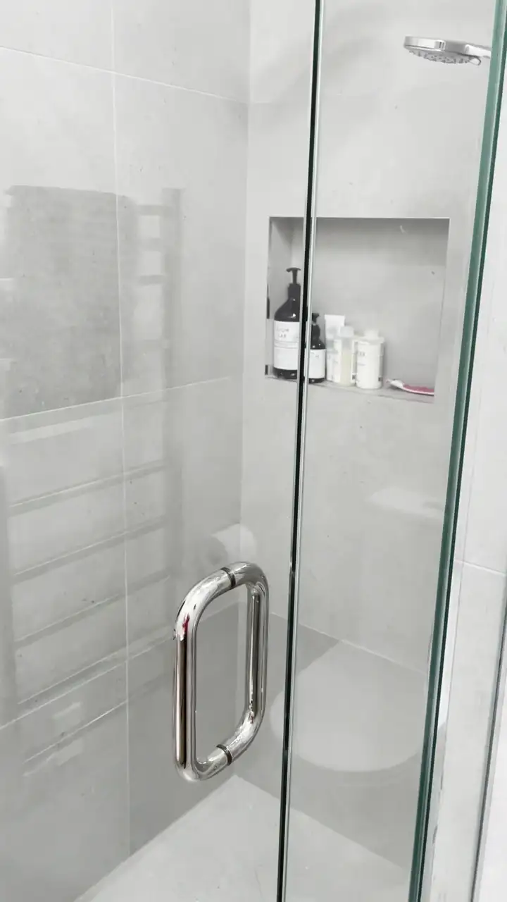 Frameless glass shower with a tiled niche and a heated towel ladder in a renovated Newmarket bathroom on Laxon Terrace