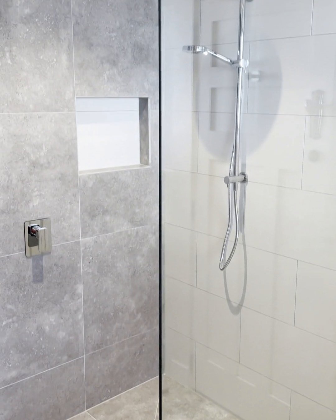 Recessed niche in a grey stone-look feature wall beside a chrome rail shower, Parnell bathroom