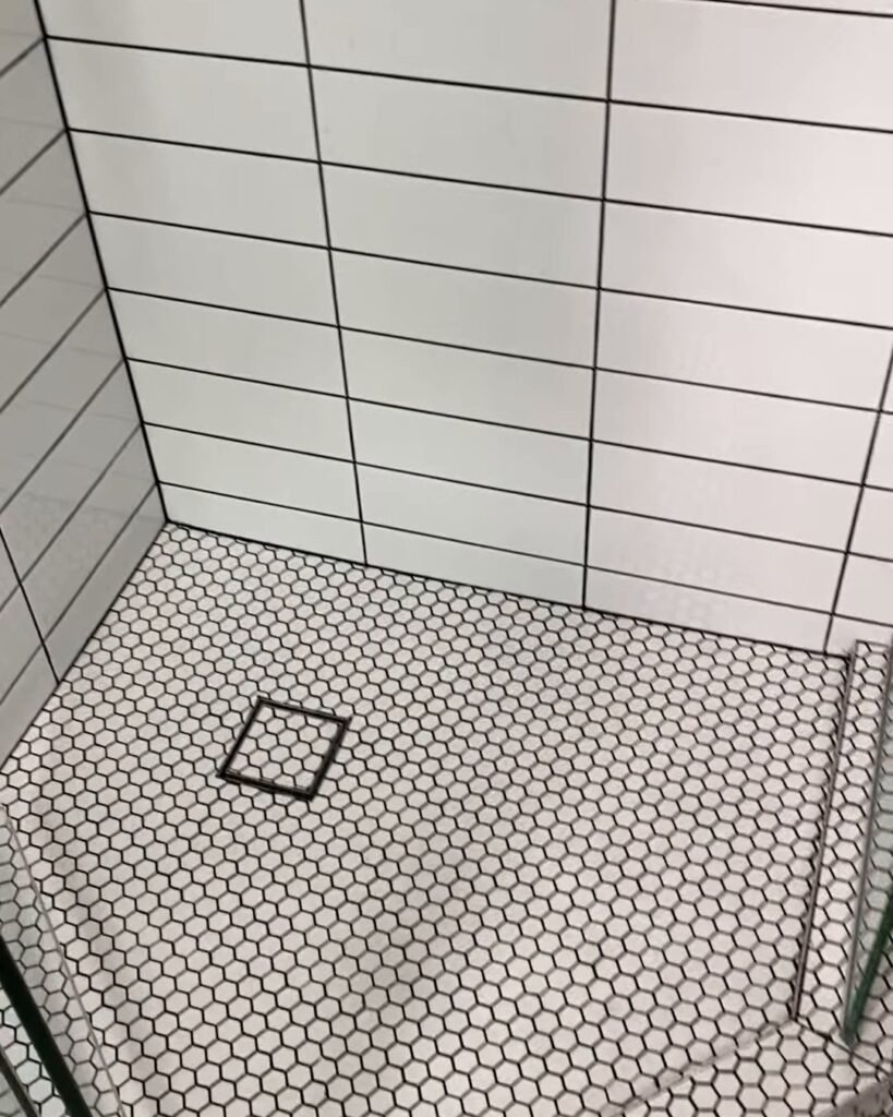Ranui bathroom renovation hexagon shower floor White hexagon mosaic shower floor with charcoal grout and a square chrome drain grate, Ranui