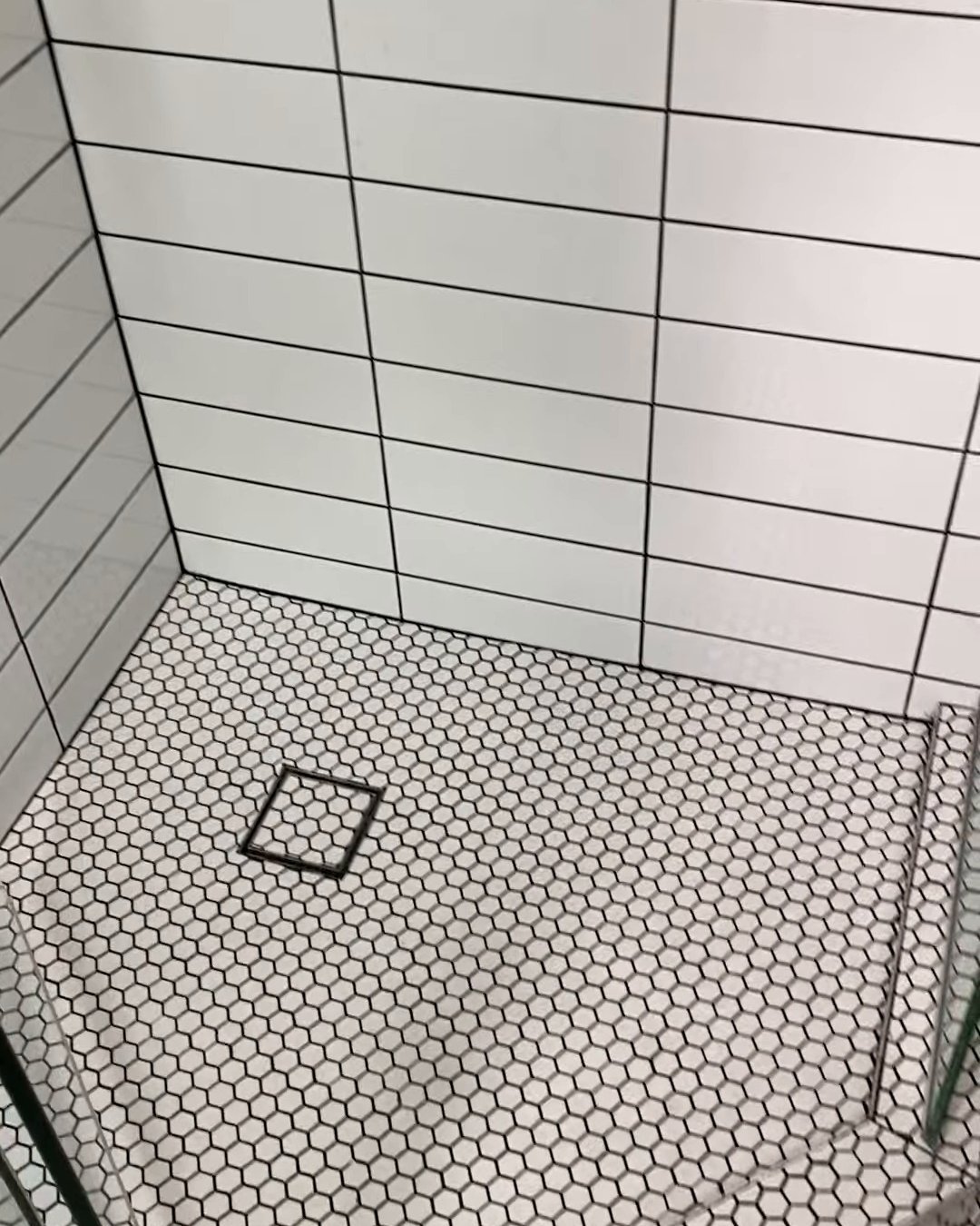 White hexagon mosaic shower floor with charcoal grout and a square chrome drain grate, Ranui