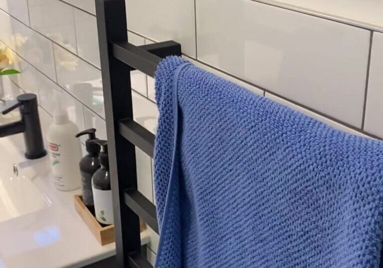 albany-bathroom-towel-rail Black heated ladder towel rail on white subway tiles beside the vanity, Albany