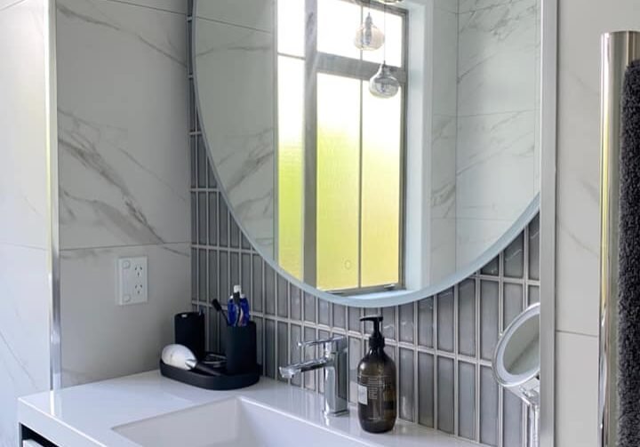bathroom contractors Floating vanity, round mirror and finger-tile splashback in a St Heliers bathroom