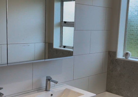 bathroom renovation botany Wide vanity with drawers and mirrored cabinet in a renovated Botany bathroom