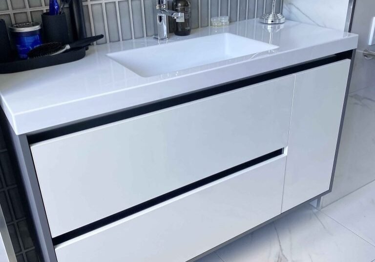 Floating vanity with drawers and a round mirror in an Alchemy bathroom renovation