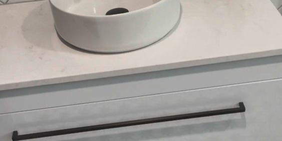 Drawer vanity with a round vessel basin and herringbone tiles in a St Johns bathroom