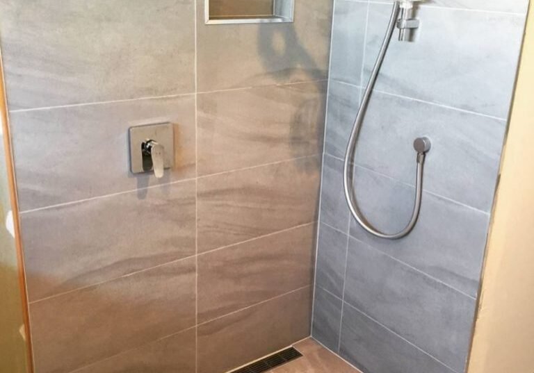 Walk-in shower with linear drain and niche in a Bayview ensuite