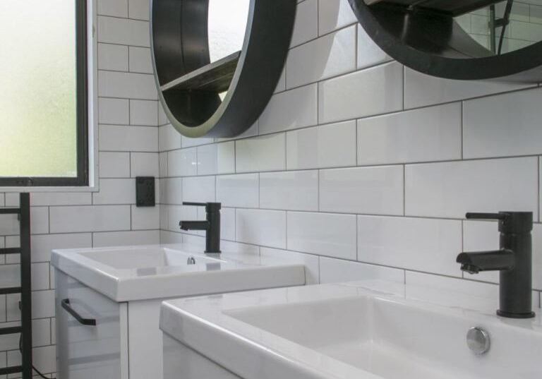 best bathroom renovations Two white floating vanities with matte black tapware in Epsom