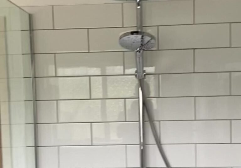 cockle-bay-shower-rail-rain-head Chrome shower rail with overhead rain head and hand shower on white subway tiles