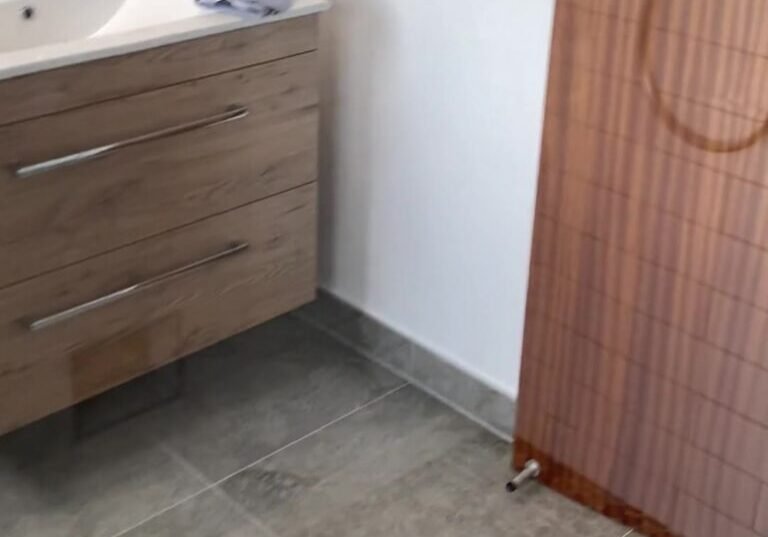 cockle-bay-vanity-and-door Wall-hung oak-look vanity with two drawers in a renovated Cockle Bay bathroom