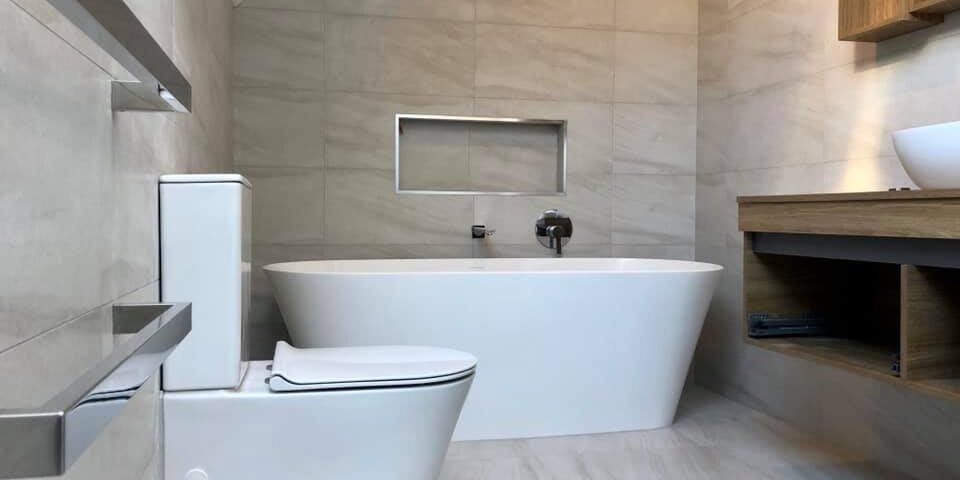 Freestanding bath under a sloped ceiling with a timber vanity in a Bayview family bathroom