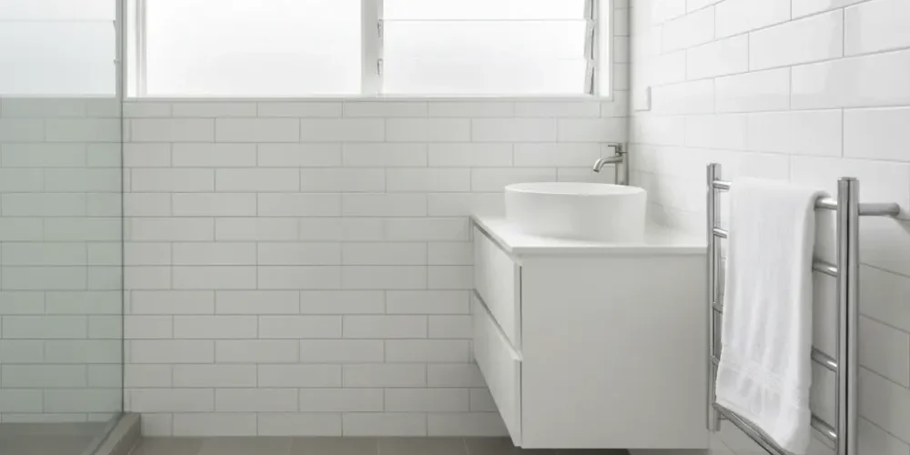 completed-ensuite-renovation-result-auckland Completed Auckland ensuite renovation with grey stone-look tiles, white subway walls, vessel basin, and chrome heated towel rail.