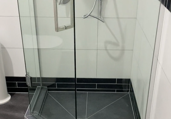 Custom tiled shower with a black tiled base and frameless glass in a Ponsonby bathroom