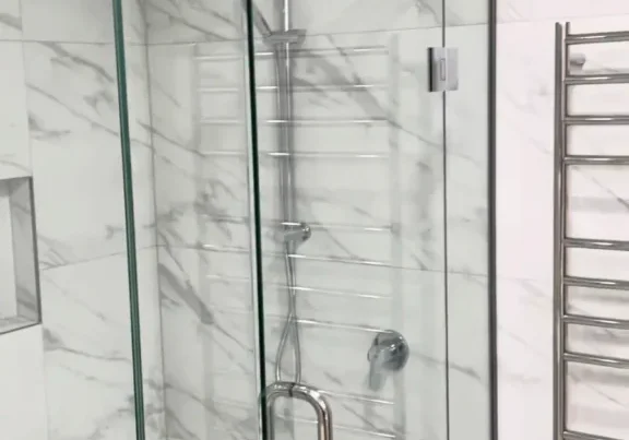 Glass corner shower with chrome rail shower and rain head in a renovated Kohimarama bathroom