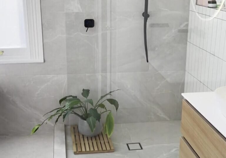 mount-eden-bathroom-shower Walk-in shower with a black rail shower and a fixed glass panel beside a sash window, Mount Eden