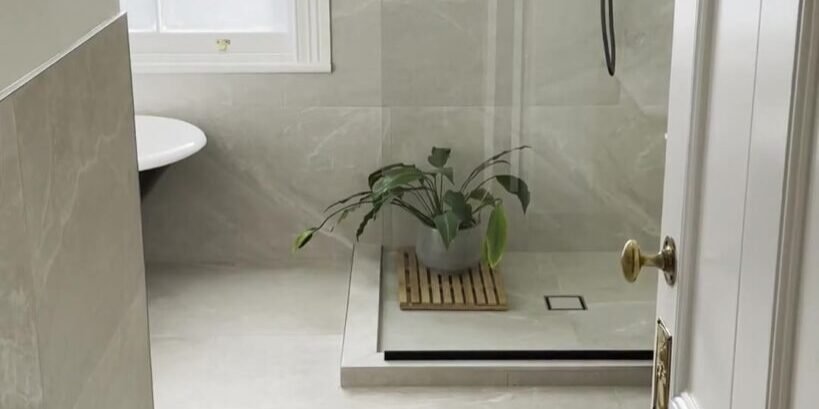 Walk-in shower and the end of a clawfoot bath seen through a panelled door, Mount Eden bathroom renovation