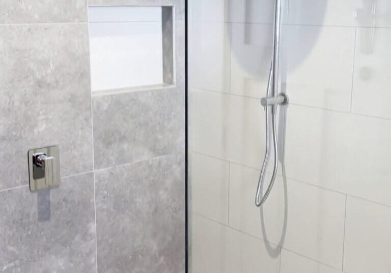 Parnell bathroom shower niche and rail shower Recessed niche in a grey stone-look feature wall beside a chrome rail shower, Parnell bathroom