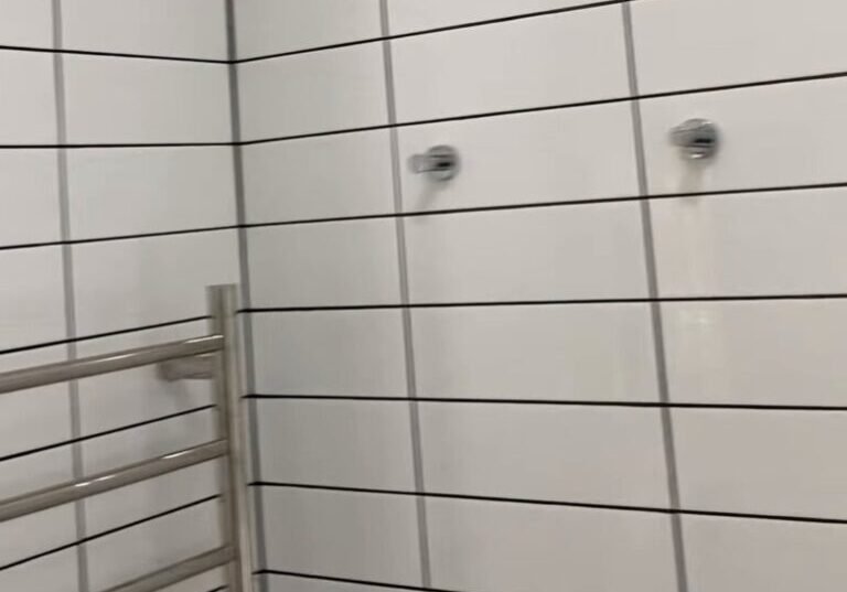 Ranui bathroom renovation towel rail Tall chrome ladder towel rail on white gloss wall tiles in a renovated Ranui bathroom