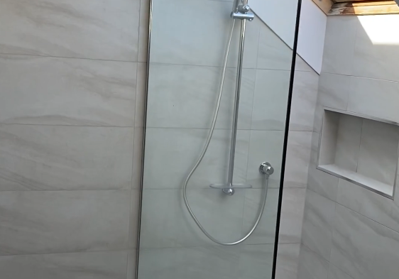 Walk-in ensuite shower under a skylight with frameless glass in Bayview